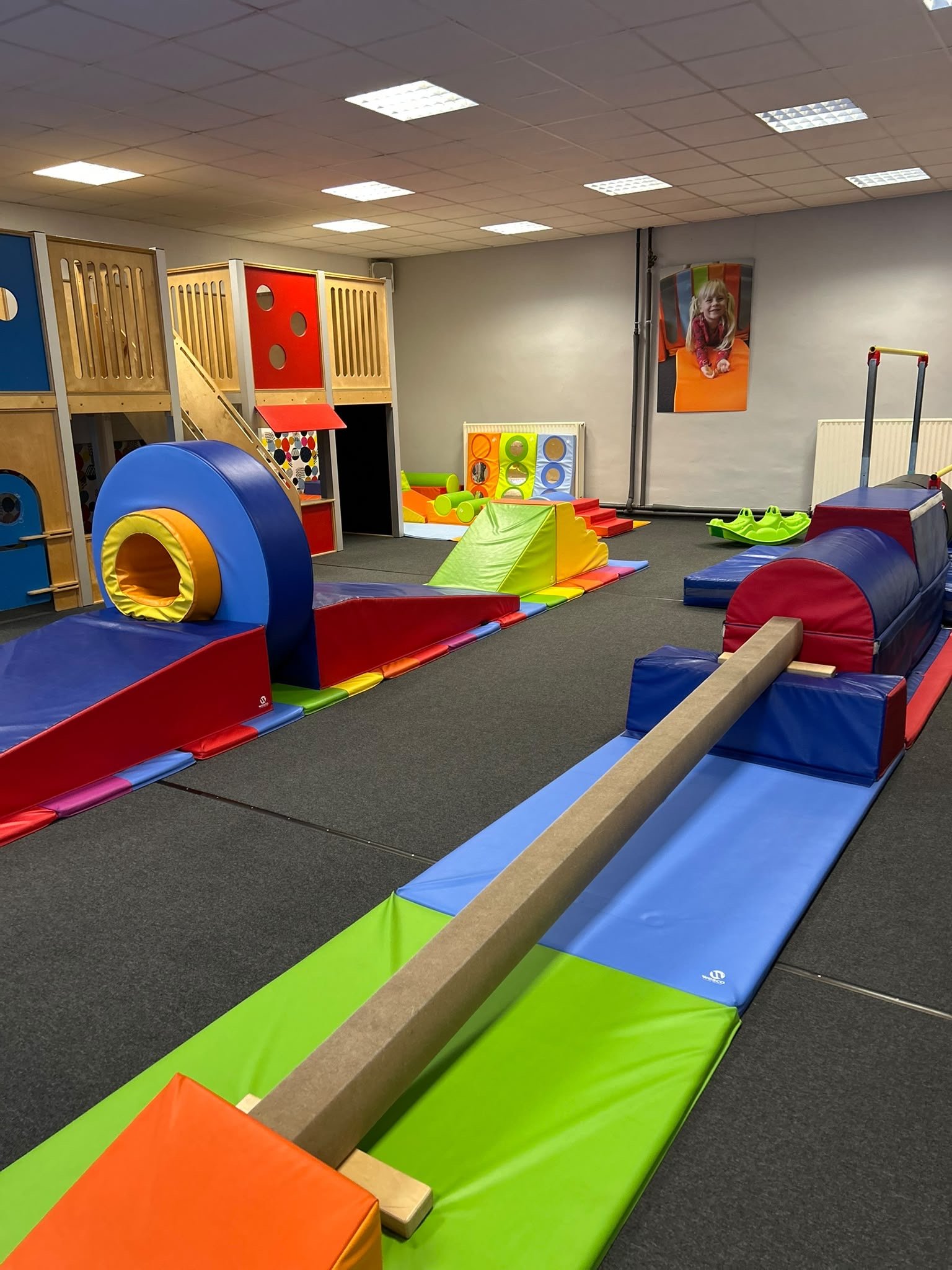 Overzicht van de kinderzaal met klimhuis, tunnel en evenwichtsparcours
