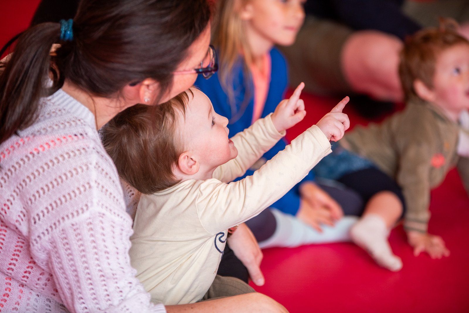 Ouders en kinderen bewegen samen met rode ballen